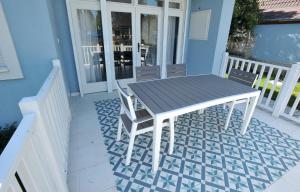 a table and two chairs on a porch with a table at LelleBlue Vendégház in Balatonlelle +16 photos