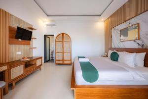 a bedroom with a large bed and a desk at Cove Tegeh Bila in Ungasan
