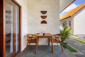 a wooden table and two chairs on a patio at Cove Tegeh Bila in Ungasan +13 photos