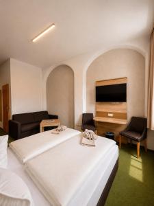 a hotel room with a bed and a flat screen tv at Pension am Markt in Wurzen +28 photos