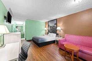a hotel room with a bed and a couch at Super 8 by Wyndham Gaffney in Gaffney