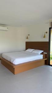 a bedroom with a large bed with white sheets at ภัสรา รีสอร์ท in Ban Nong Khla