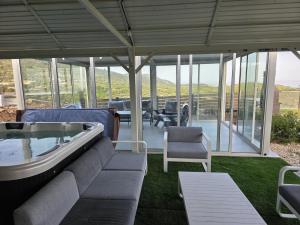 a living room with a couch and a table and chairs at Velen Harmony- בקתות מושלמות עם בריכה במתחם in ‘Ein el Asad