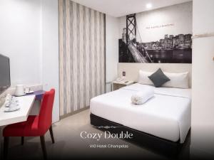 a hotel room with a bed and a desk and a computer at Vio Cihampelas in Bandung