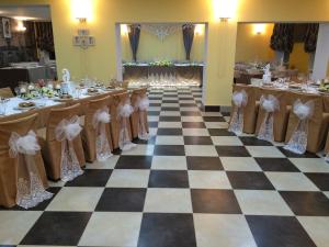 a banquet hall with a checkered floor and tables at AMBER Hotel & Cafe in Bohorodchany