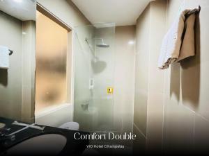 a bathroom with a shower and a glass door at Vio Cihampelas in Bandung +32 photos