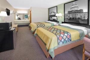 Habitación de hotel con 2 camas y TV de pantalla plana. en Super 8 by Wyndham Clarksville AR, en Clarksville
