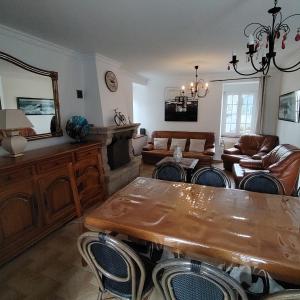 a living room with a wooden table and chairs at Chez Albert au bord de plage in Cherrueix