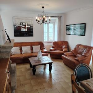a living room with leather couches and a table at Chez Albert au bord de plage in Cherrueix