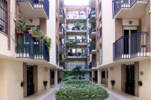 Une allée dans un immeuble d'appartements avec balcon et plantes dans l'établissement Apartamento Azahara, à Cordoue