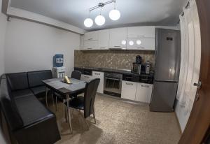 a small kitchen with a table and a refrigerator at Elegant Private Villa with 3 Bedrooms, Office, and shared courtyard, Perfect for 8 Guests in Piteşti