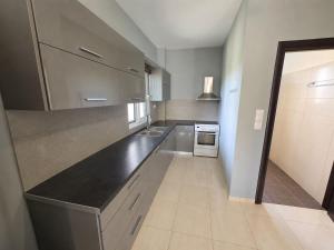a large kitchen with a black counter top in a room at Patras Ressort in Patra