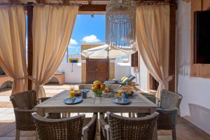 a dining table and chairs in a room with a patio at Casa Aestas in Lachania