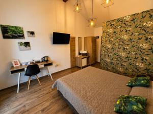 a bedroom with a bed and a desk and a television at Hill House in Drobeta-Turnu Severin