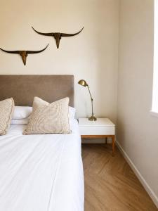 a bedroom with a bed with two antlers on the wall at Cape Central Designer Suite in Cape Town +21 photos