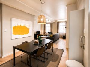 a living room with a black table and chairs at Cape Central Designer Suite in Cape Town