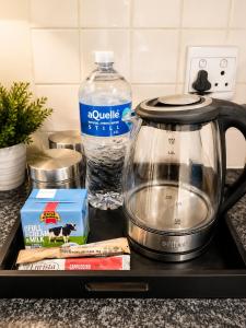 a tea kettle and a bottle of water on a counter at Cape Central Designer Suite in Cape Town