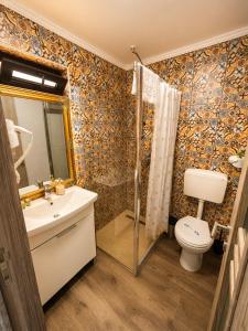 a bathroom with a toilet and a sink and a shower at Hill House in Drobeta-Turnu Severin
