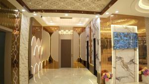 a hallway of a building with paintings on the walls at Thejaiparadise by jai hotel in Rohtak +14 photos