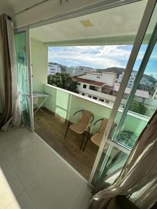 a room with a view of a balcony with two chairs at Apartamento 2 quartos 100m Prainha in Arraial do Cabo