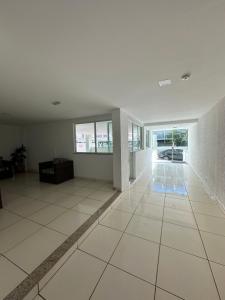 a large empty room with white tile floors and windows at Apartamento 2 quartos 100m Prainha in Arraial do Cabo