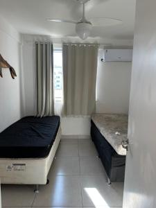 a small bedroom with two beds and a window at Apartamento 2 quartos 100m Prainha in Arraial do Cabo +20 photos