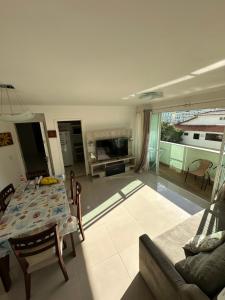 a living room with a table and a fireplace at Apartamento 2 quartos 100m Prainha in Arraial do Cabo