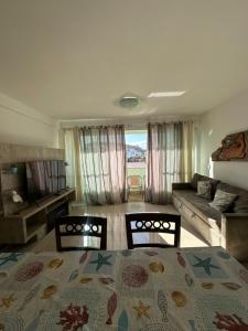 a living room with a bed and a couch at Apartamento 2 quartos 100m Prainha in Arraial do Cabo
