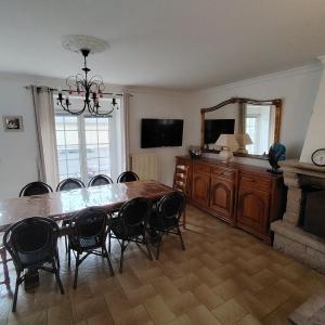 a dining room with a table and chairs and a mirror at Chez Albert au bord de plage in Cherrueix +10 photos