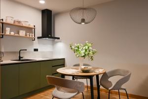 a kitchen with a table with chairs and a vase of flowers at Albatross Home in Ķesterciems