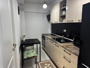 a kitchen with white cabinets and a black counter top at A&C Studio Techirghiol in Techirghiol