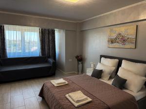 a bedroom with a bed and a couch at A&C Studio Techirghiol in Techirghiol