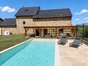 a house with a swimming pool in front of a building at Gîte Le Granit des Champs in Mainsat