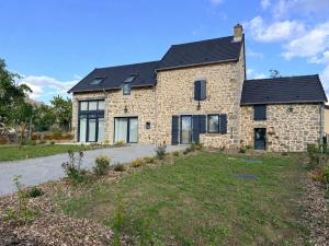 a stone house with a black roof at Gîte Le Granit des Champs in Mainsat