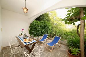 a patio with a table and chairs and an archway at Apartment Mare Monti in Ičići