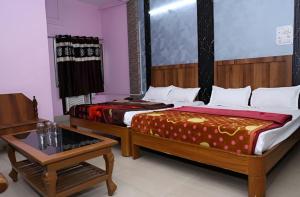 a room with two beds and a table and a tableasteryasteryasteryasteryastery at Hotel Hill View in Jamshedpur