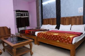 a room with two beds and a table and a tableasteryasteryasteryasteryastery at Hotel Hill View in Jamshedpur +14 photos