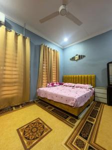 a bedroom with a bed with pink sheets and a ceiling at SYA Homestay Bachok in Bachok