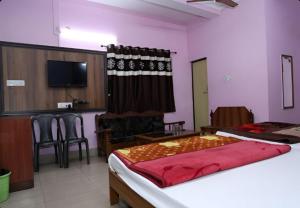 a bedroom with a bed and a table and chairs at Hotel Hill View in Jamshedpur