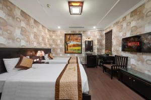 a hotel room with two beds and a desk at Binh Anh Hotel in Hanoi