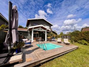a backyard deck with a pool and a house at Entre bassin & océan in Lège-Cap-Ferret
