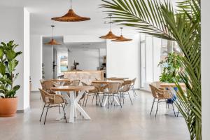 ein Esszimmer mit Tischen, Stühlen und Pflanzen in der Unterkunft HSM Atlantic Park in Magaluf