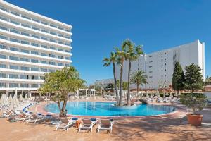 ein Schwimmbad mit Liegestühlen und ein Hotel in der Unterkunft HSM Atlantic Park in Magaluf