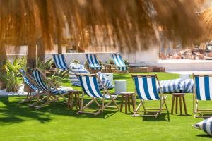 eine Gruppe von Stühlen und Tischen auf dem Rasen in der Unterkunft HSM Atlantic Park in Magaluf