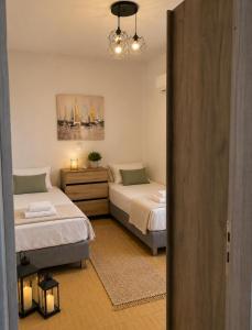 a bedroom with two beds and a door to a room at Villa Harmonia I -Elegant Retreat in Karlovasi