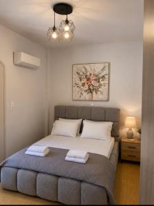 a bedroom with a bed with two towels on it at Villa Harmonia I -Elegant Retreat in Karlovasi +2 photos