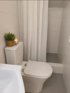 a white bathroom with a toilet with a plant on it at Villa Harmonia I -Elegant Retreat in Karlovasi