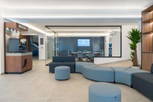 an office lobby with blue furniture and a conference room at Hotel Vibra Vila -3SUP- New Opening 2026 in Ibiza Town