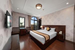 a bedroom with a bed and a desk and a window at Binh Anh Hotel in Hanoi