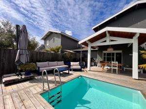 a backyard with a swimming pool and a wooden deck at Entre bassin & océan in Lège-Cap-Ferret